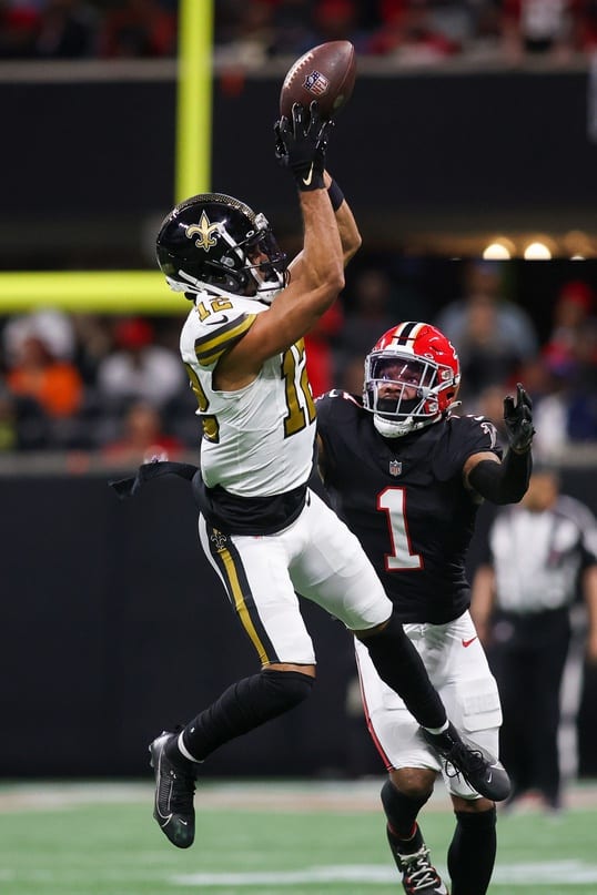 New Orleans Saints receiver Chris Olave (12) catches a pass over Atlanta Falcons cornerback Jeff Okudah (1). Mandatory Credit: Brett Davis-USA TODAY